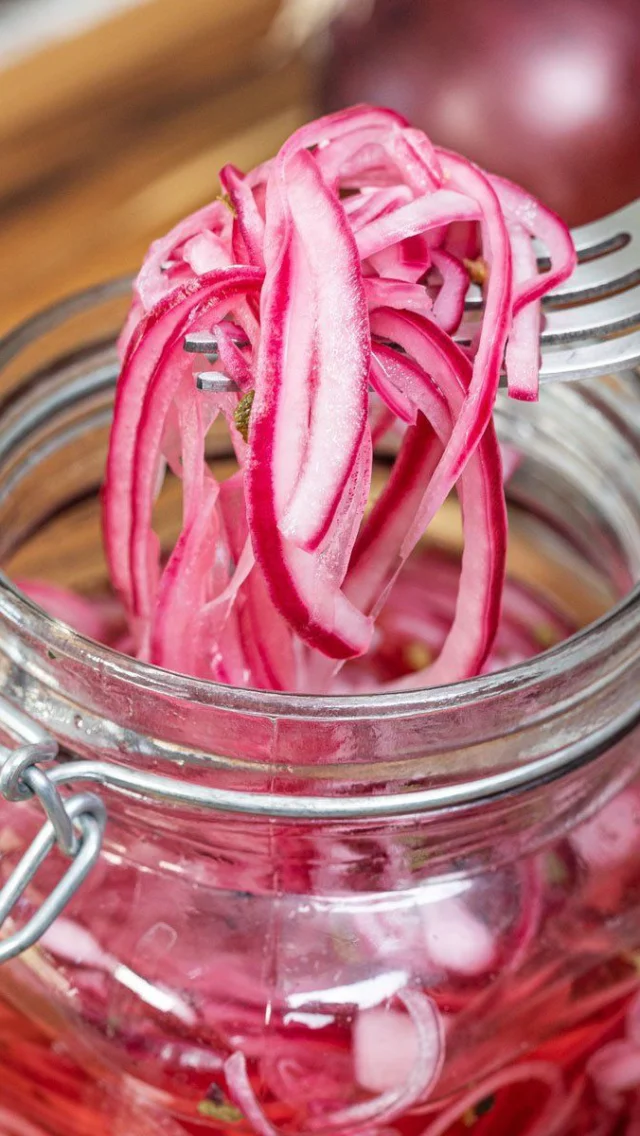 ¿Por qué me encanta? 🧅🤍La cebolla roja encurtida no solo es sabrosa y versátil en la cocina, sino que también ofrece varios beneficios para la salud, gracias a los nutrientes de la cebolla y al proceso de encurtido.🧅 1. Rica en antioxidantesEs rica en quercetina, un potente antioxidante que ayuda a combatir el estrés oxidativo y la inflamación. Además tiene potencial antialérgico.El color rojo proviene de los antocianinas, también con efectos antioxidantes y antiinflamatorios.🦠 2. Mejora la salud intestinalEl vinagre ayuda al proceso digestivo y si además dejamos fermentar el producto … Aportamos probióticos a nuestra comida. 🦠🩺 3. Ayuda a controlar el azúcar en sangreLos compuestos de la cebolla favorecen la mejoría de la sensibilidad a la insulina ayudándonos a regular las glucemias🍽️ 5. Mejora la absorción de mineralesEl vinagre (ácido acético) puede ayudar al cuerpo a absorber mejor minerales como el calcio, hierro y magnesio presentes en otros alimentos 🥑🥣🦐 Un toque de sabor y un extra crujiente para unas ensaladas súper completas en estos días de 🔥 Receta 🧑‍🍳🧑‍🍳🧑‍🍳Añade a un cazo medio vaso de vinagre de manzana, 1 vaso de agua, 1 cda de azúcar y una de sal. Calentar hasta que rompa a hervir. En ese momento lo paras, y cuando no esté hirviendo, añades la cebolla previamente troceada y cortada fina. Lo dejas un ratito hasta que enfríe. Lo envasas en cristal y a partir de 12-16 horas … está perfecto para consumir 😊😍Disfruta